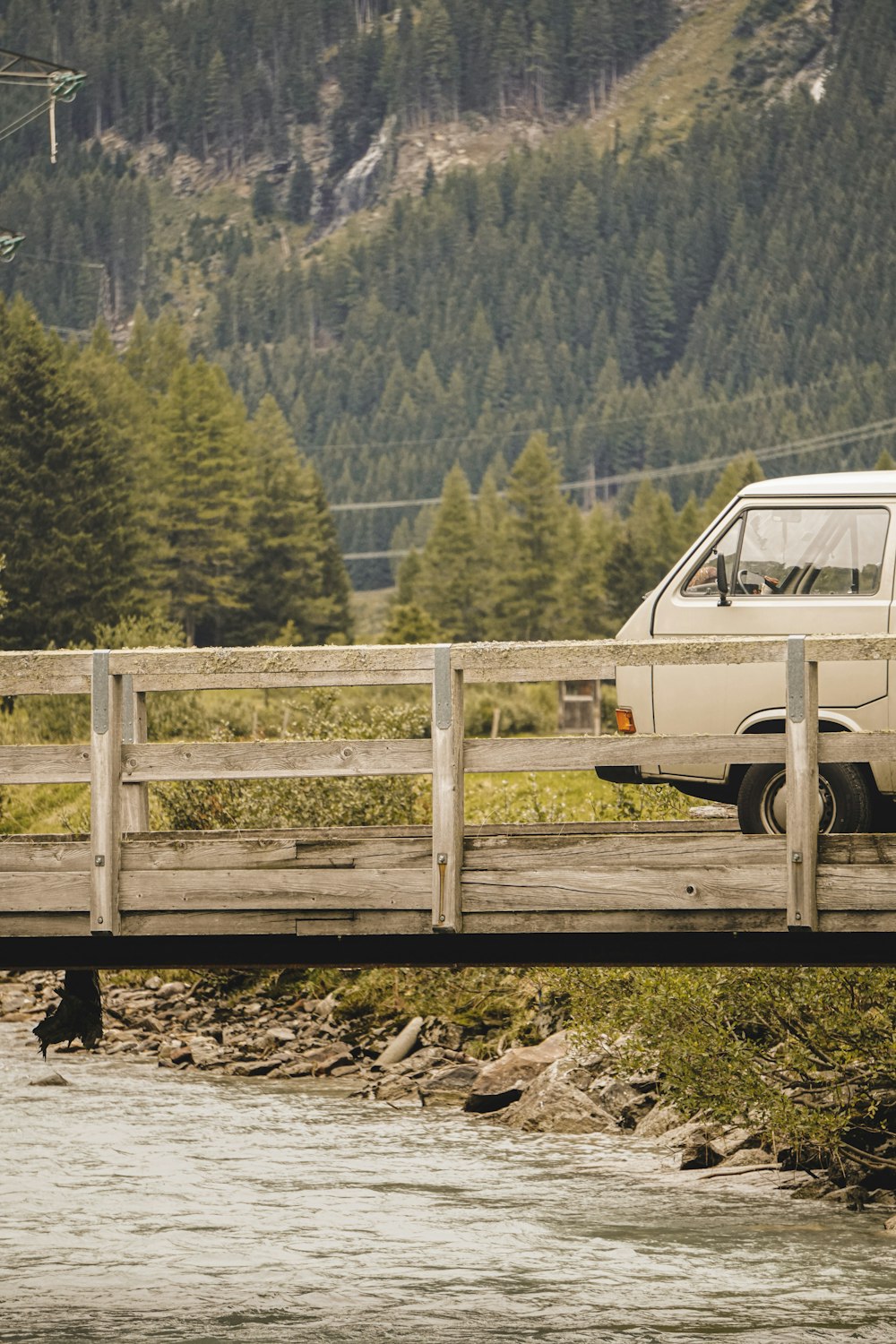 white van on dirt road near green trees during daytime