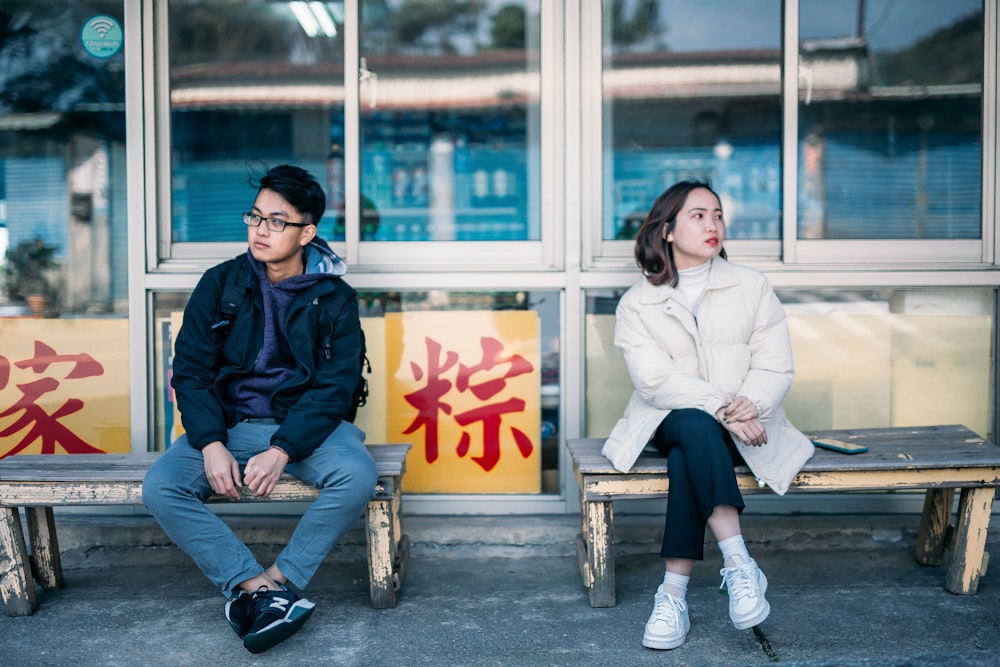 man and woman sitting on bench