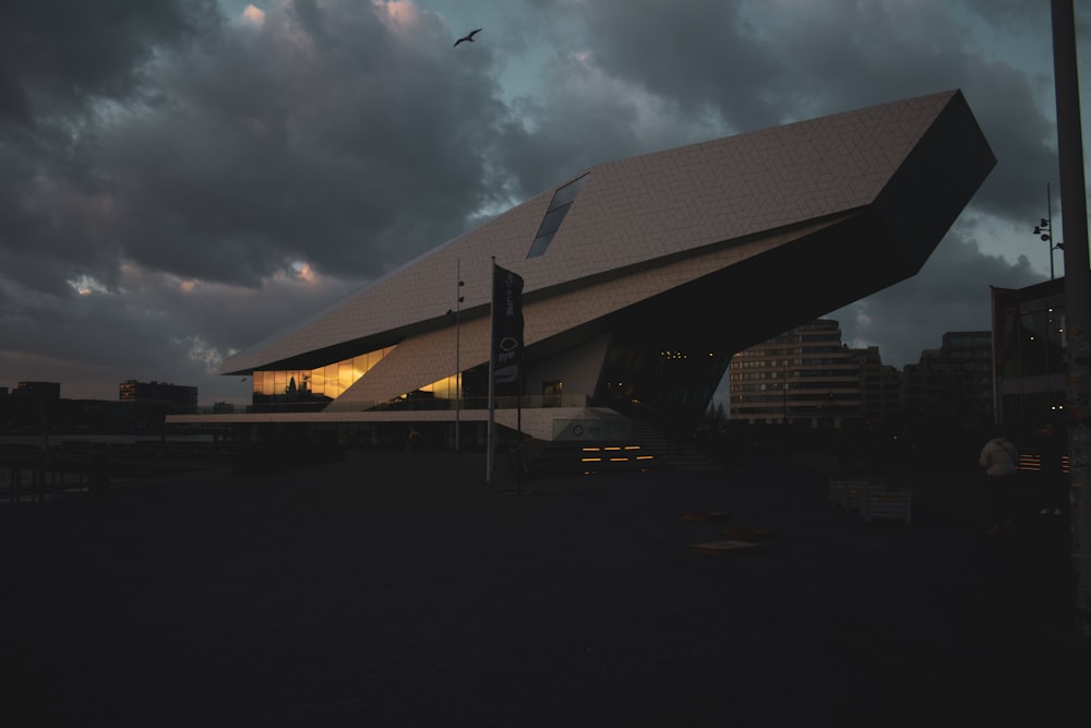 edifício de concreto branco e preto sob nuvens cinzas durante o dia