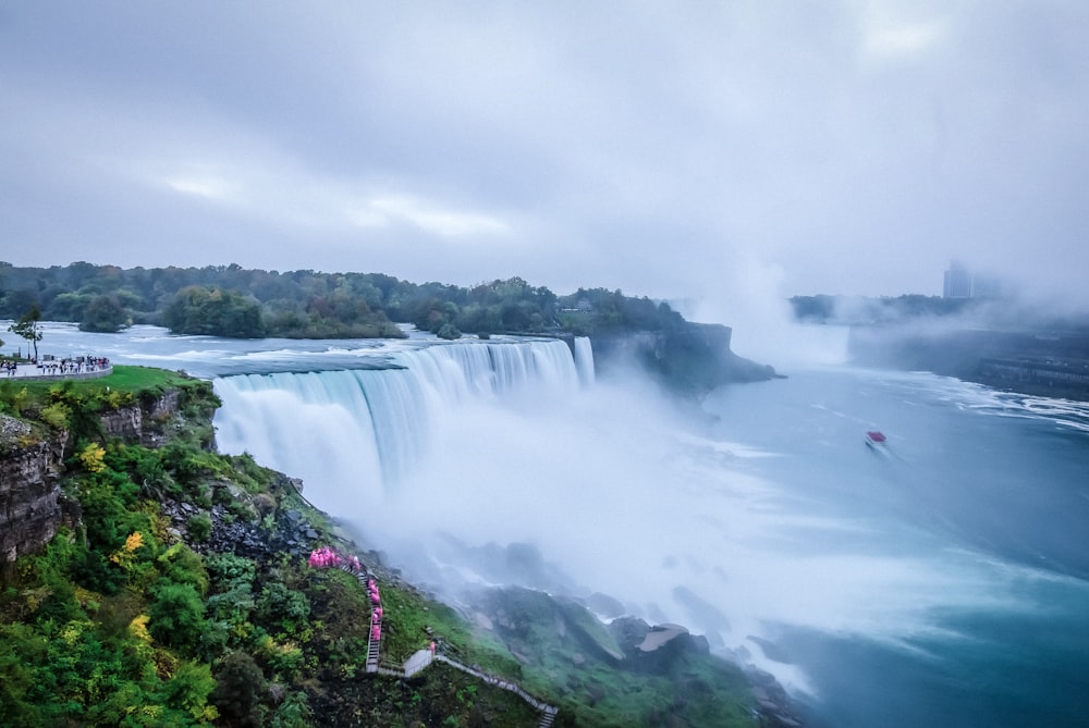 waterfalls under white cloudy sky during daytime