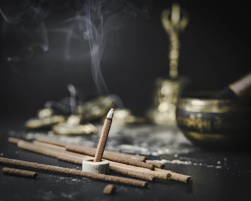 Brown wooden incense sticks on brass round bowl