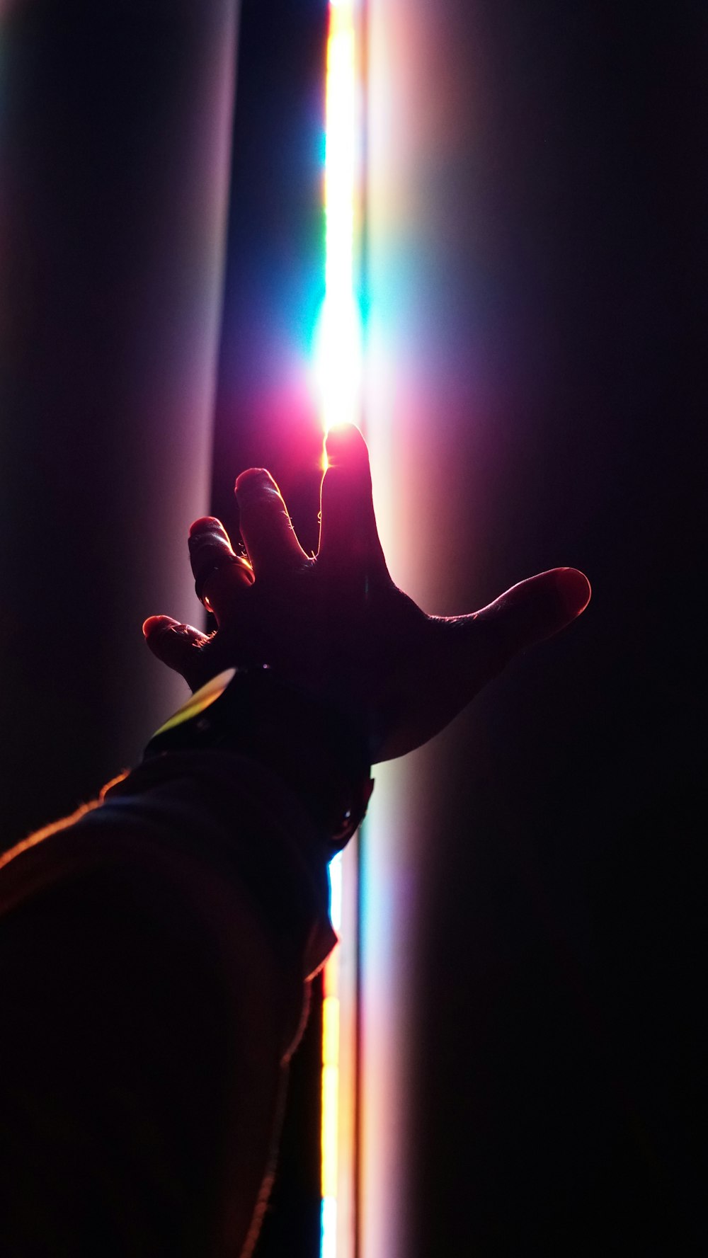 person holding lighted candle in dark room