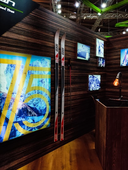 Cozy ski shop interior with wooden shelves filled with skis, boots, and winter gear under warm lighting.