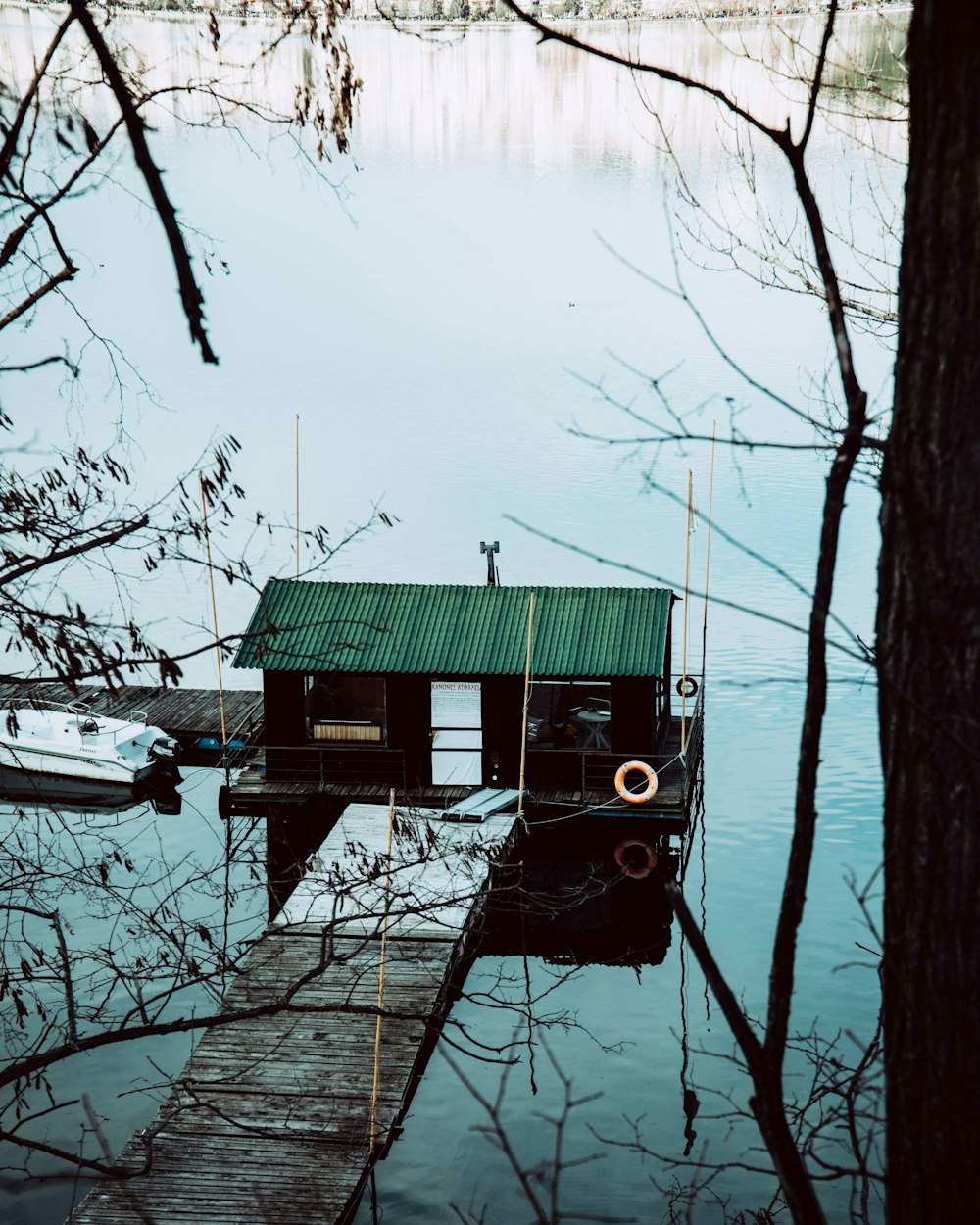 green wooden house on lake during daytime