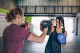 man in red t-shirt wearing blue boxing gloves