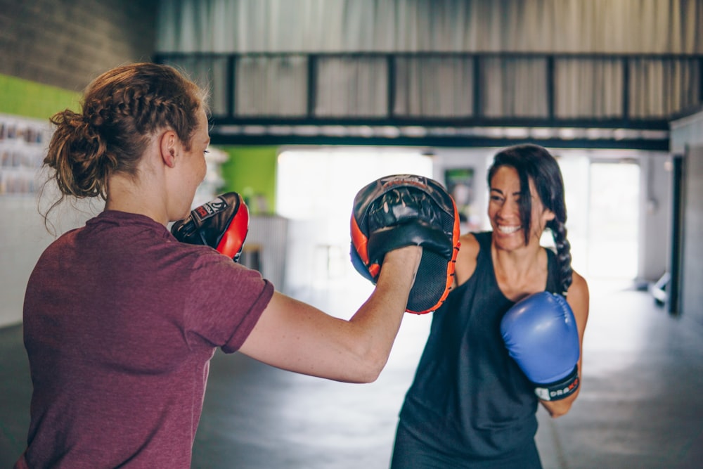 man in red t-shirt wearing blue boxing gloves