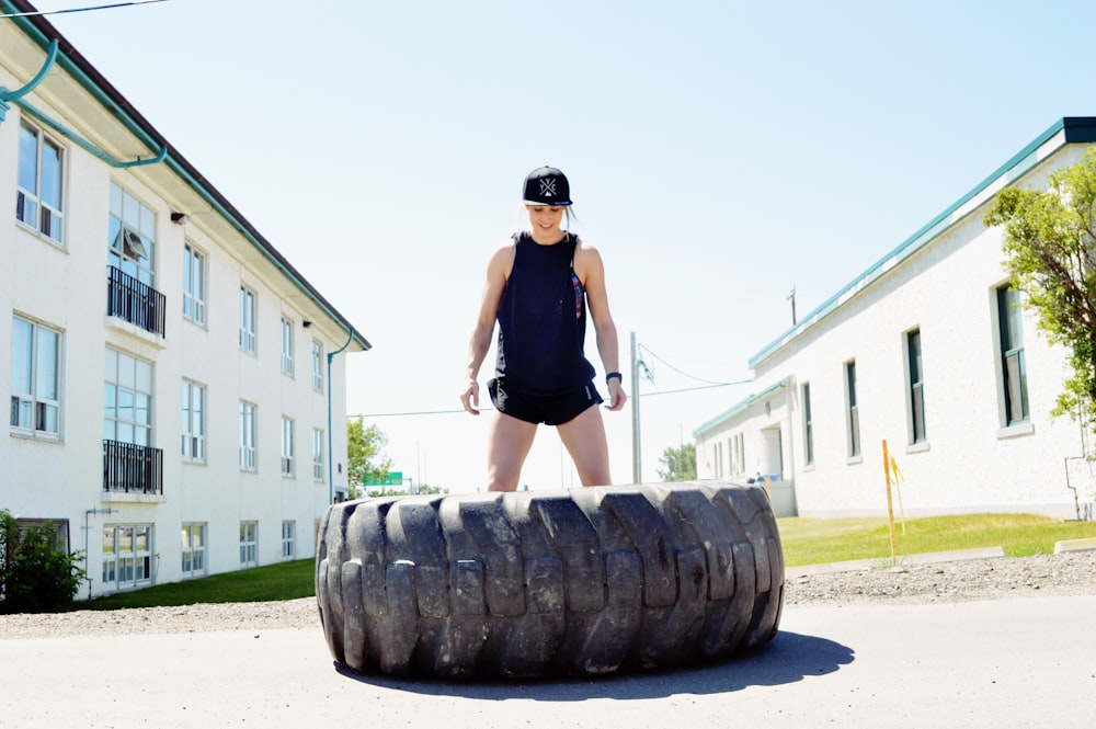 woman in black tank top and black shorts standing on black and gray rock