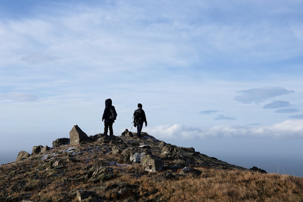 2 person standing on rock formation during daytime