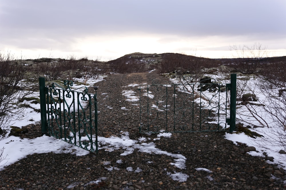 black metal fence on snow covered ground during daytime