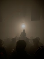 Audience silhouettes moving gently in a dimly lit club, immersed in sound.
