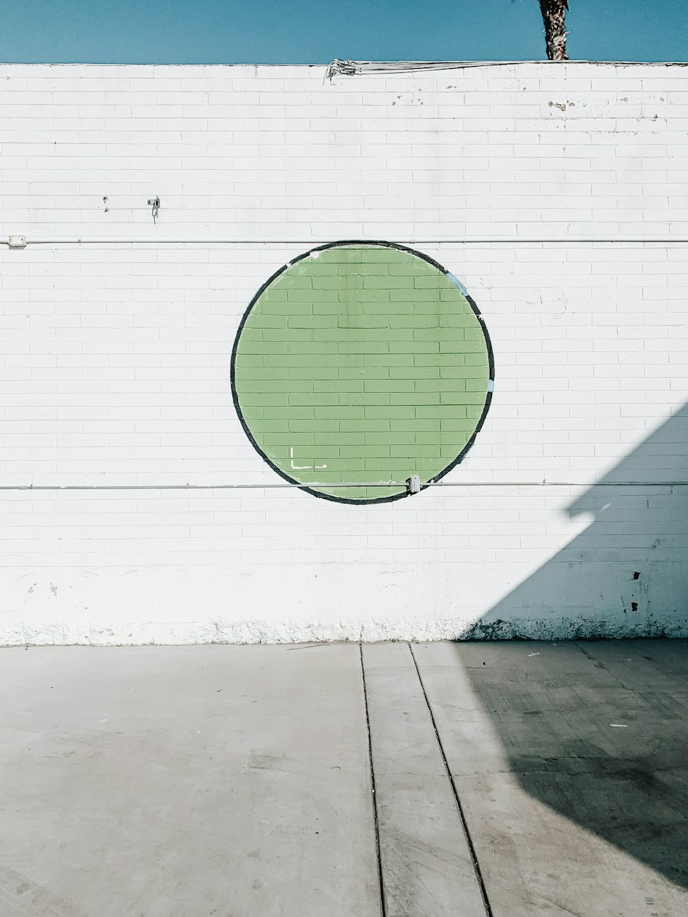 白い壁に緑の丸いボール
