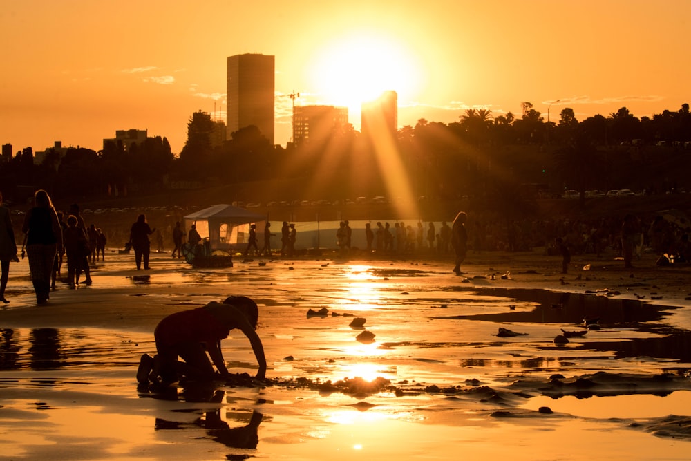 people walking on wet road during sunset