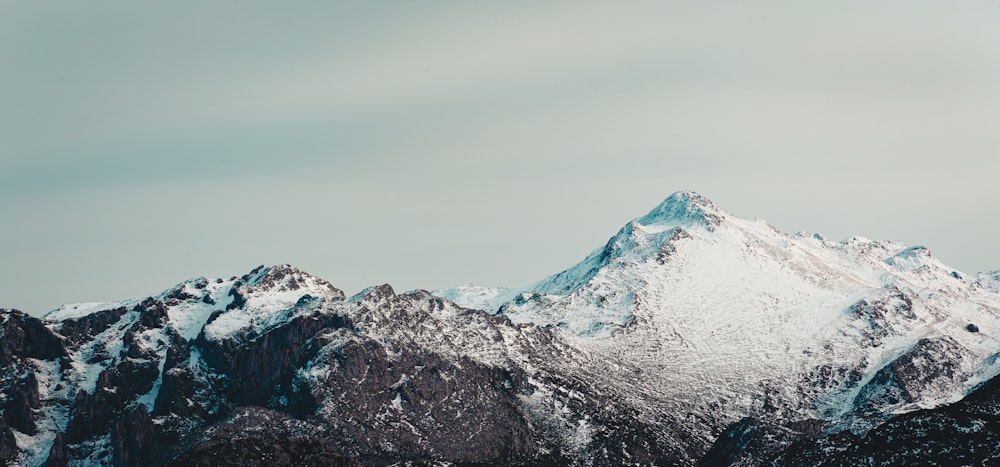 snow covered mountain under gray sky