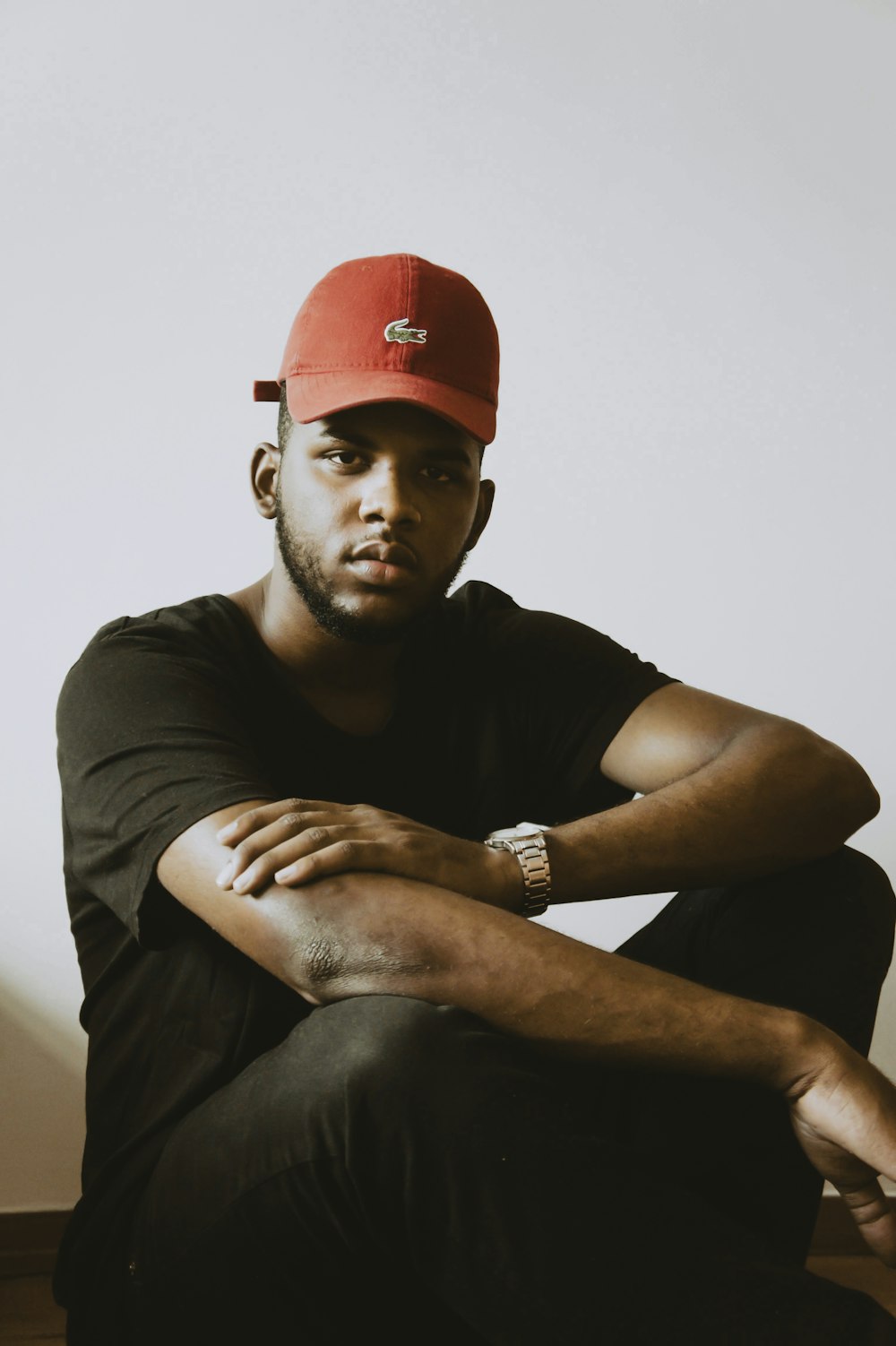 man in black crew neck t-shirt wearing red cap