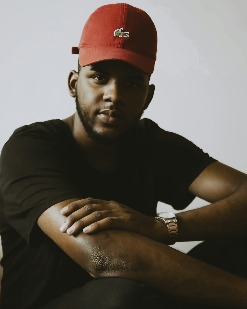 man in black crew neck t-shirt wearing red cap