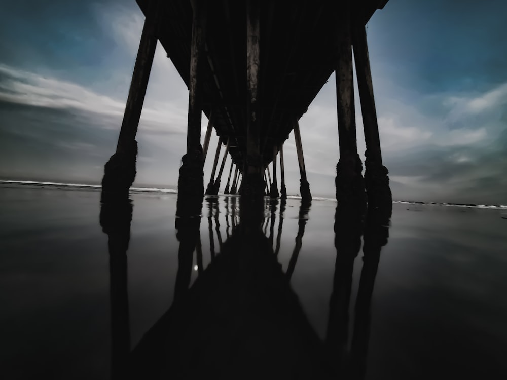 brown wooden dock on body of water under blue sky during daytime