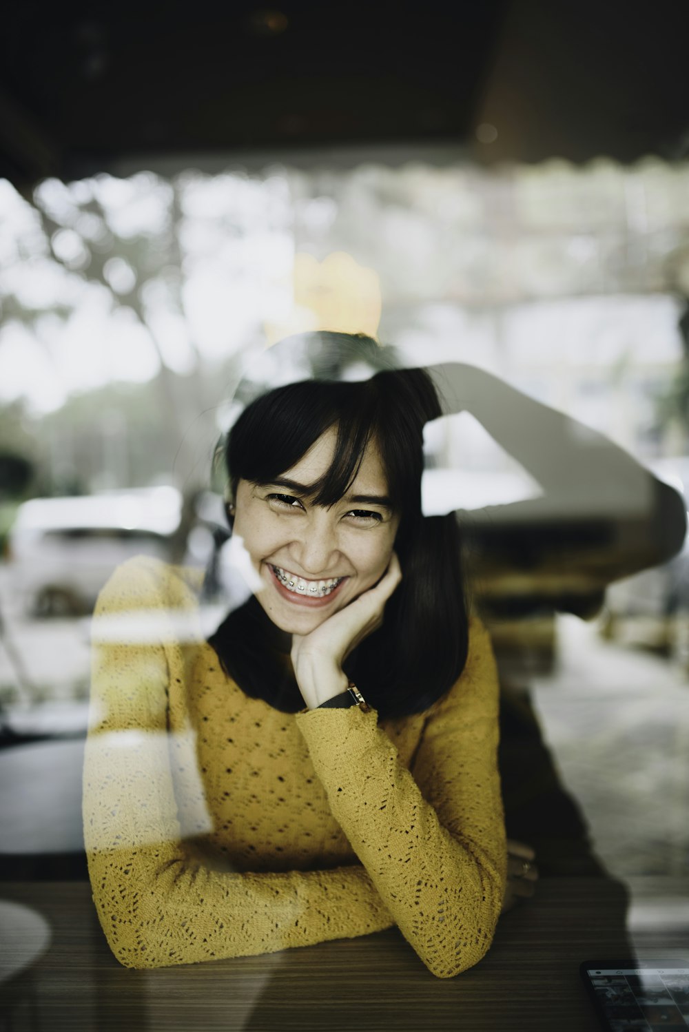woman in yellow knit sweater smiling