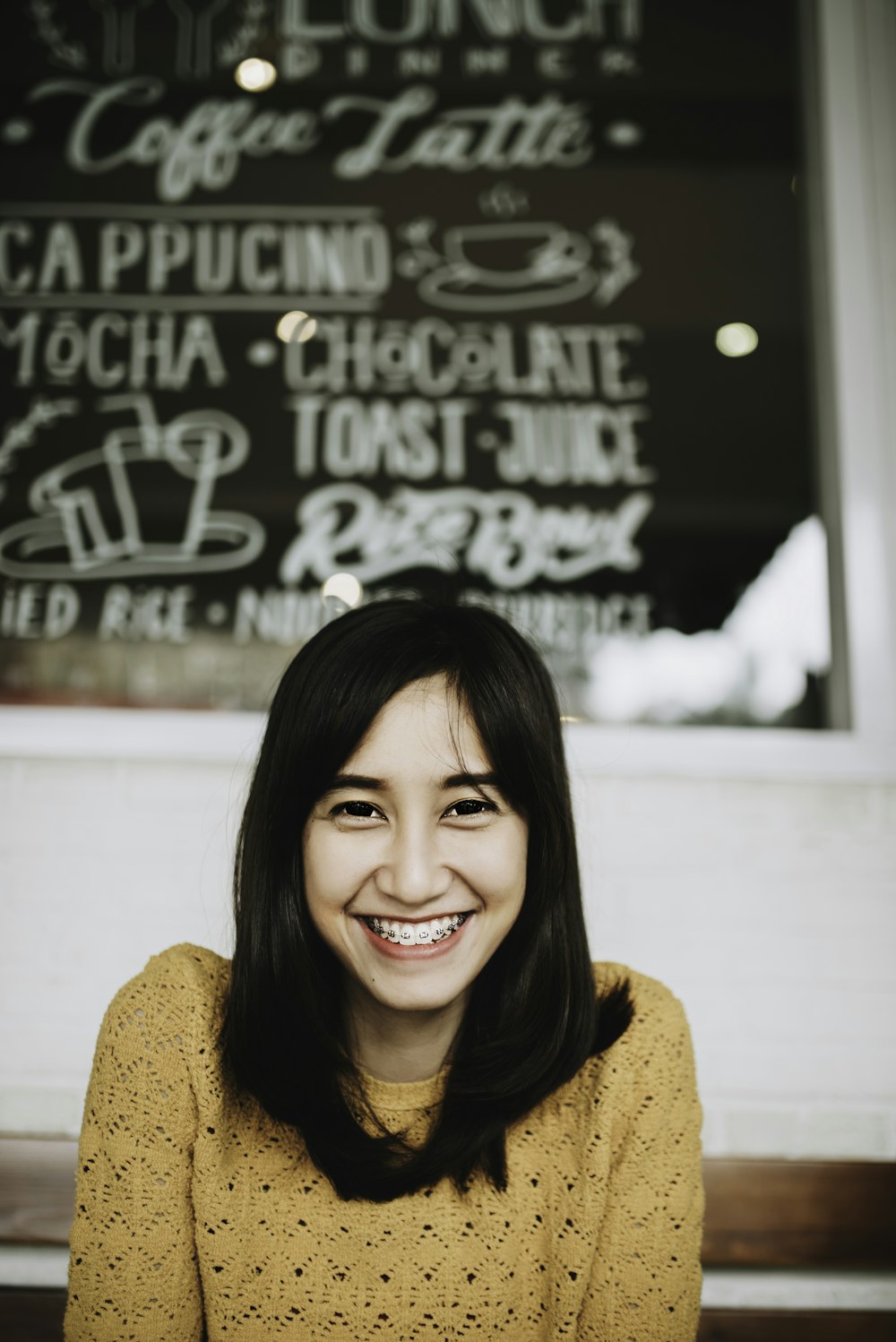 woman in orange knit sweater smiling