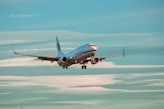 blue and white airplane in the sky during daytime