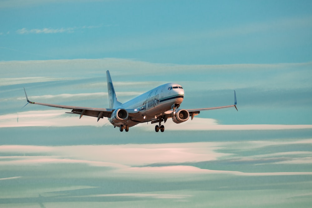 昼間の空に浮かぶ青と白の飛行機