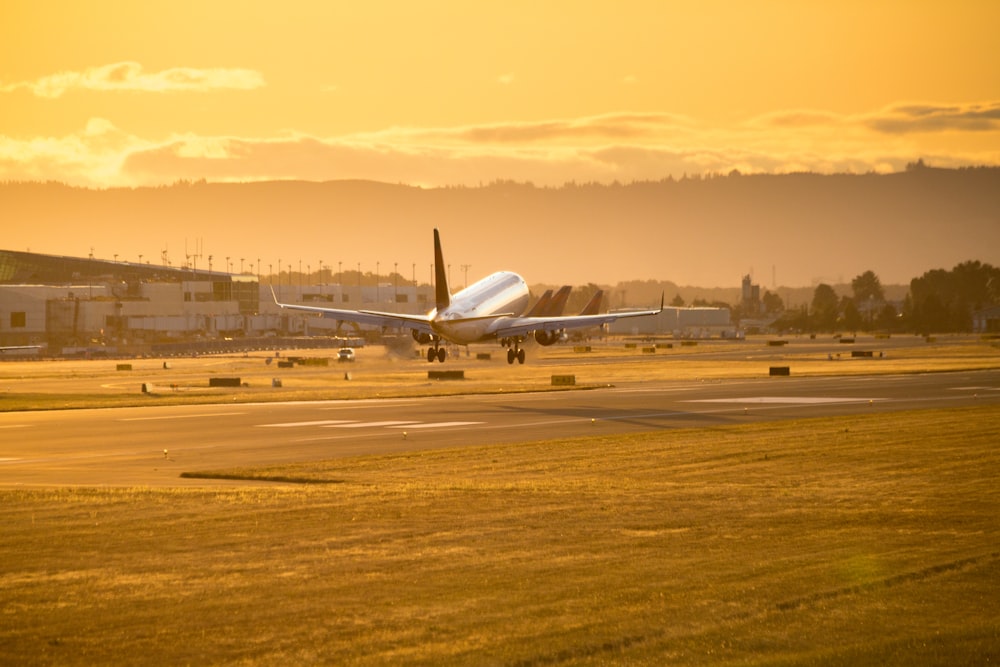 Weißes Flugzeug tagsüber auf braunem Feld