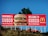 A large McDonald's advertisement billboard stands against a clear blue sky. It features a prominent image of a Big Mac burger, with the text 'BIENVENIDOS A CUSCO' and 'WELCOME TO CUSCO'. The billboard is located near some greenery and appears to be positioned on a raised platform or hill.