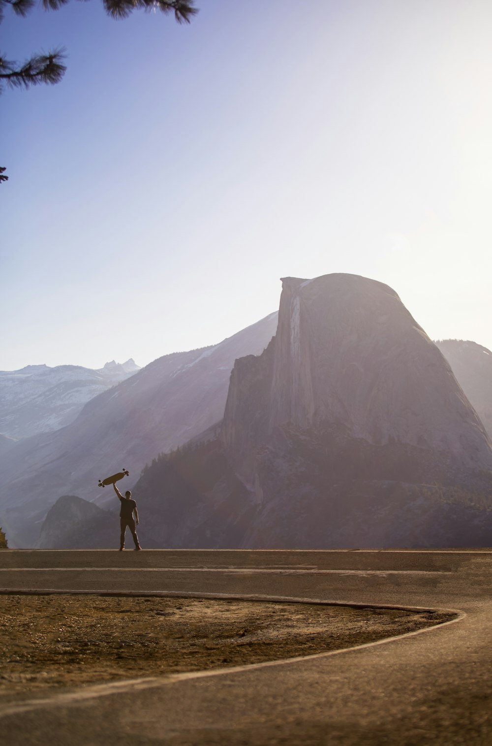 person standing on brown dirt road near mountain during daytime