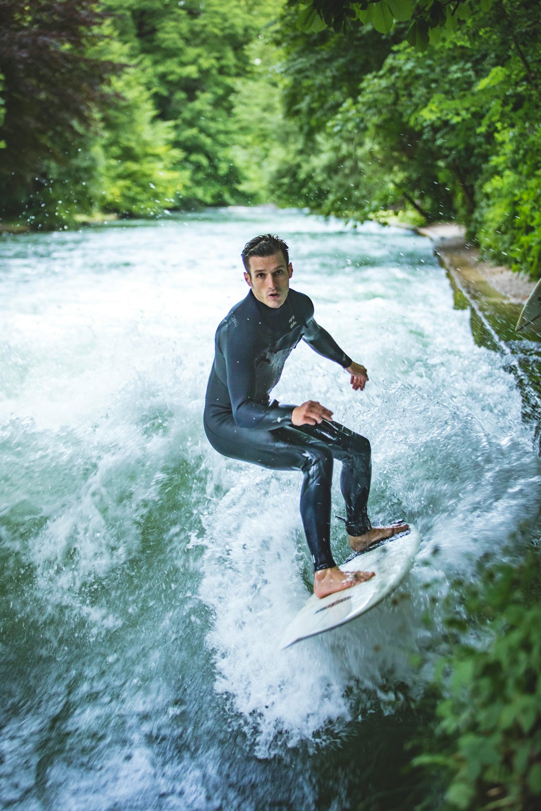 man in black jacket and blue denim jeans riding on brown surfboard on water during daytime