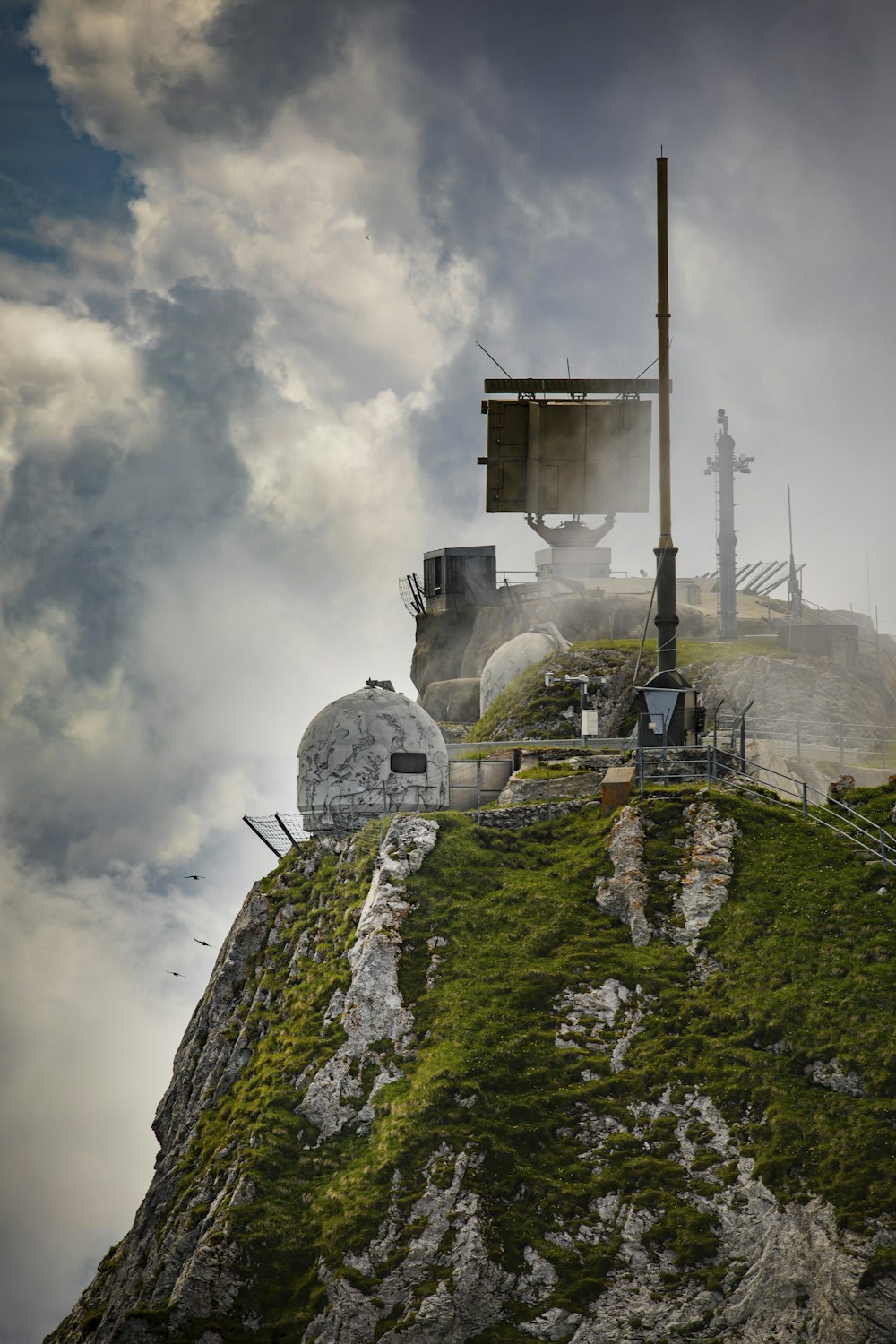 white concrete building on top of mountain under cloudy sky during daytime