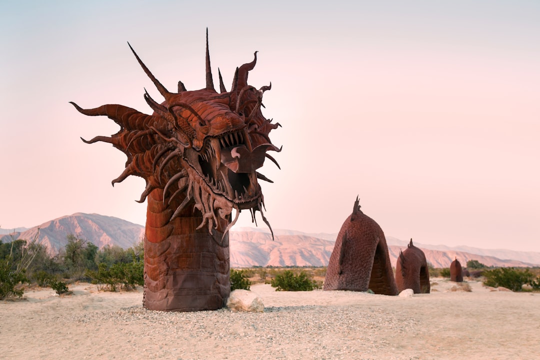 brown dragon statue on white sand during daytime