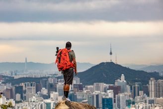 A backpacker enjoying a city view while their bags are safely stored nearby.