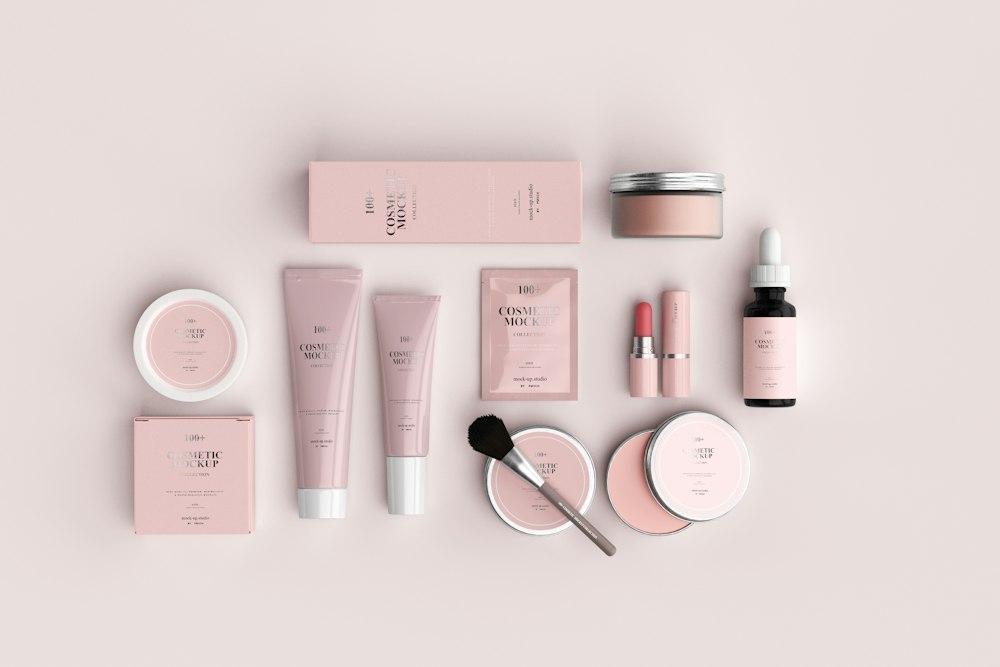 Skincare and beauty products laid out on a pink background