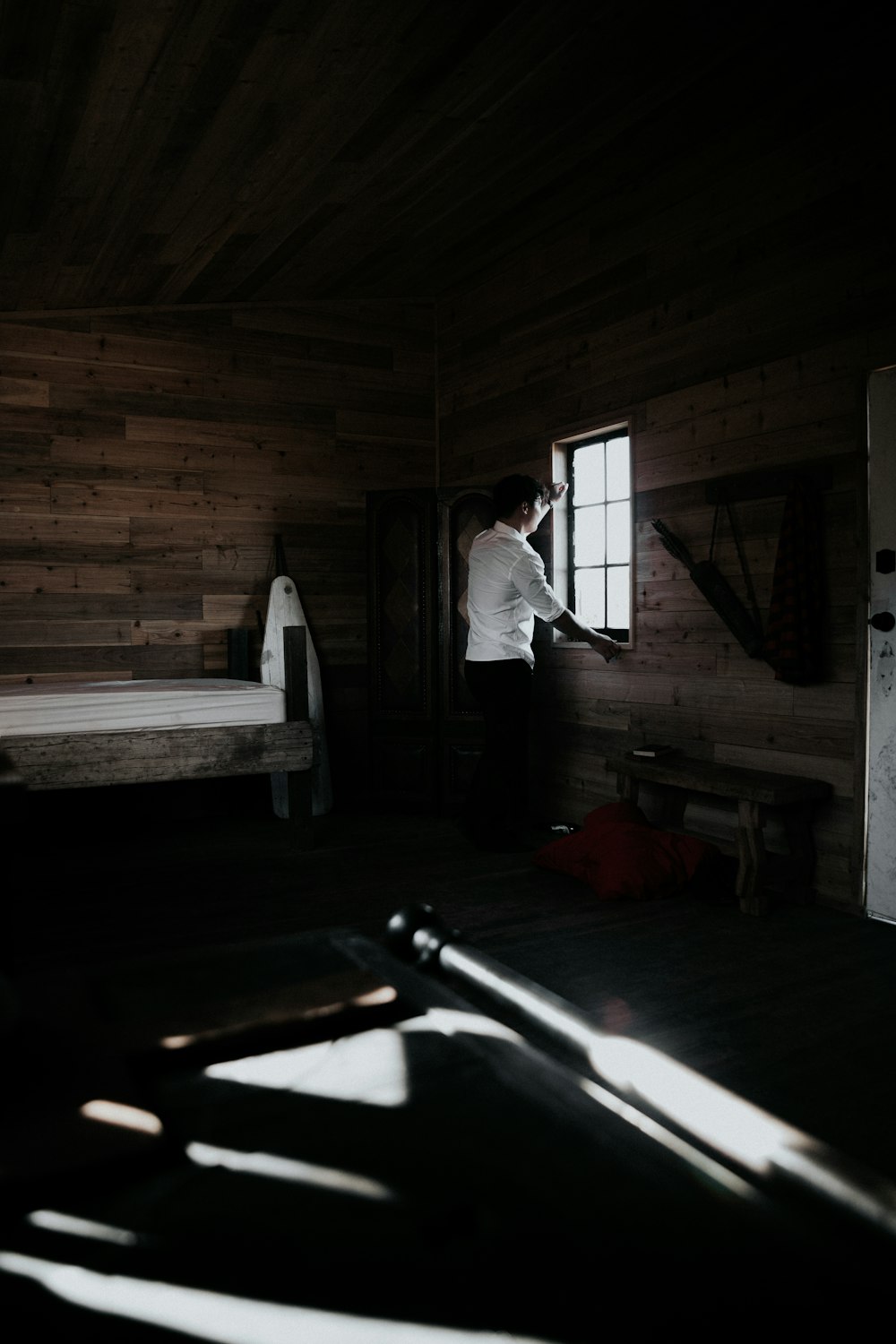 man in white dress shirt and gray pants standing on brown wooden floor