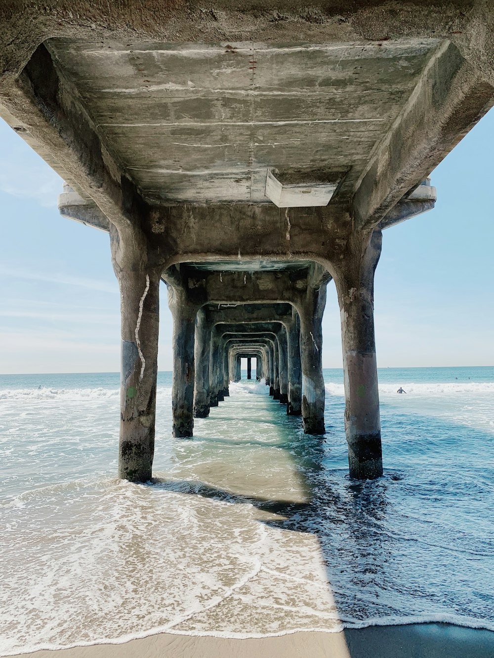 edificio in cemento grigio sulla riva del mare durante il giorno