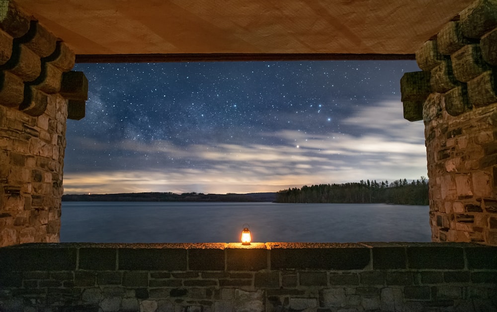 body of water near trees under blue sky during night time