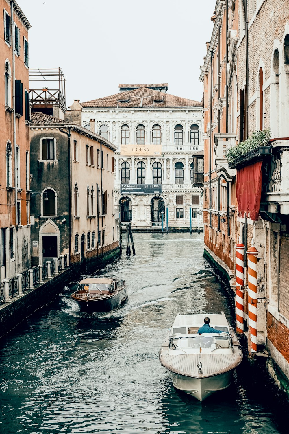 boat on river between buildings during daytime