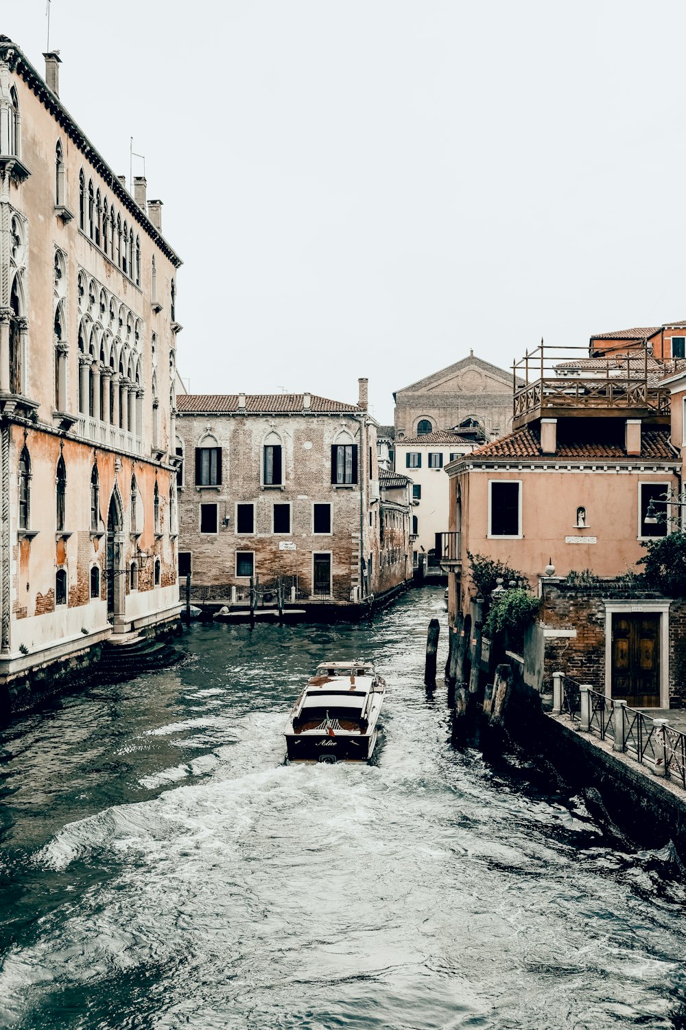 boat on river between buildings during daytime