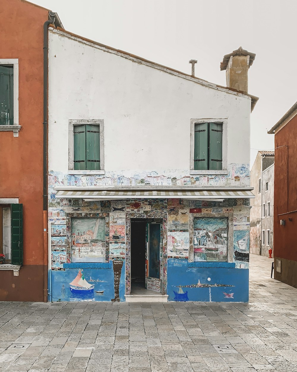 blue trash bin beside brown concrete building during daytime