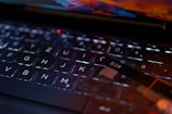 A close-up view of a keyboard with a focus on the keys. A transparent card with the text 'N26' is positioned on the keyboard, indicating a digital or banking theme. The lighting creates reflections and highlights that add a modern and technological feel.