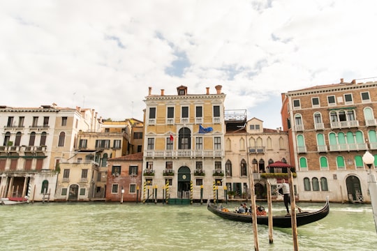 brown and white concrete building beside body of water during daytime in Rialto Bridge Italy