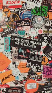 Close-up of colorful stickers with bold phrases and artistic designs on a black background