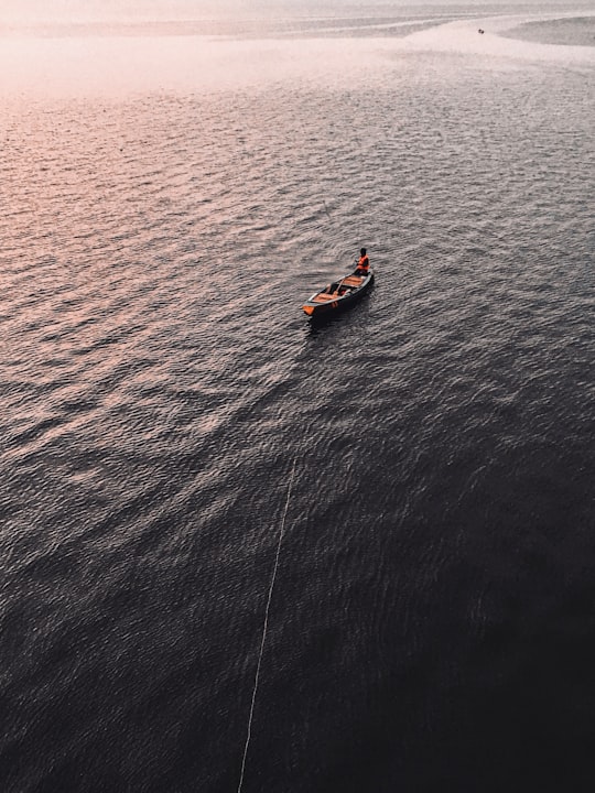 2 people riding on orange kayak on blue sea during daytime in Vijayawada India