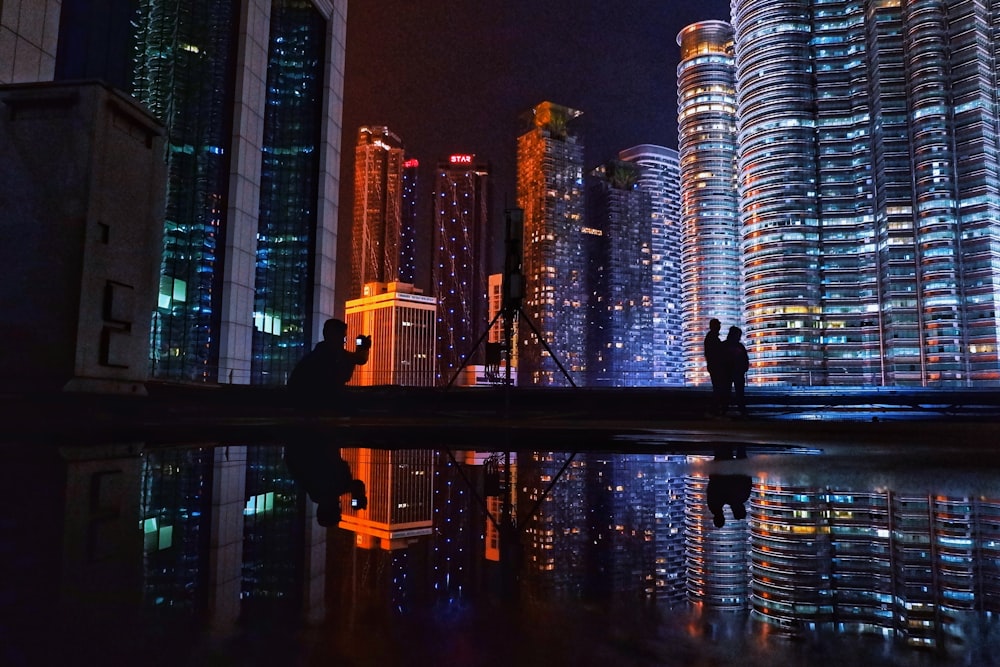 silhouette of man standing on bridge during night time