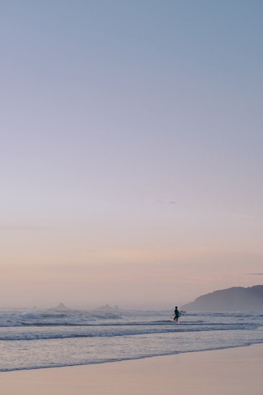 silhouette of man standing on seashore during daytime in Byron Bay Australia