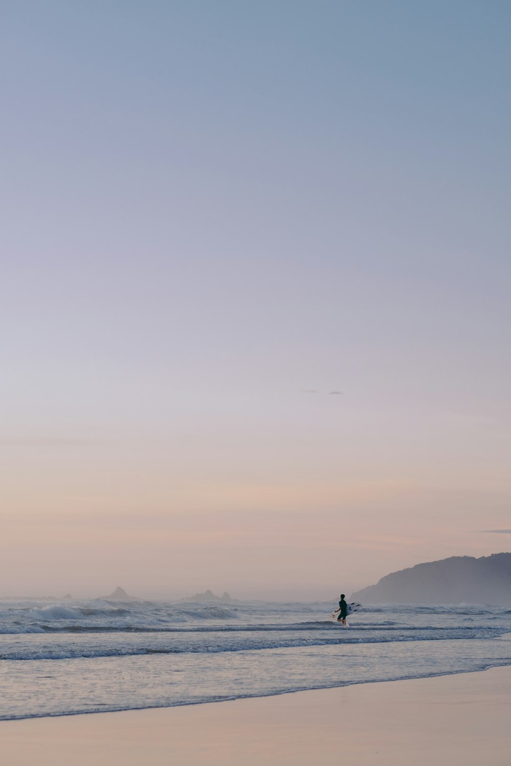 silhouette of man standing on seashore during daytime