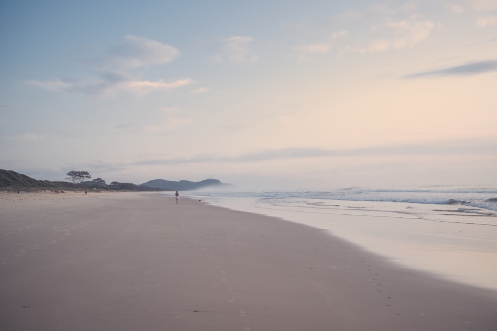 person walking on beach during daytime