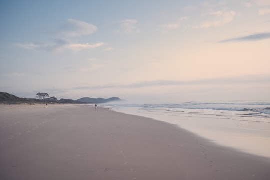 person walking on beach during daytime in Byron Bay Australia