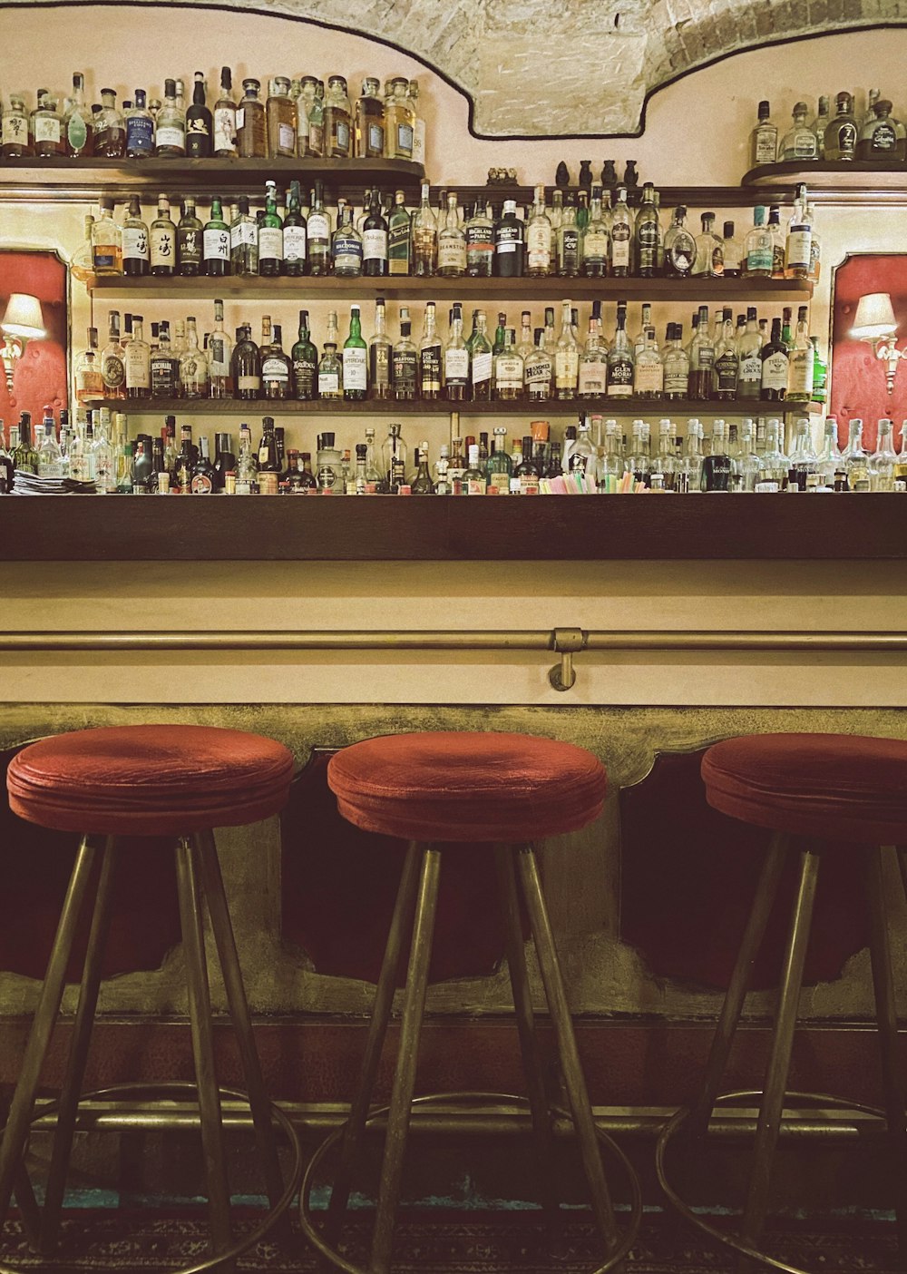 Tabourets de bar en bois marron à côté du comptoir de bar