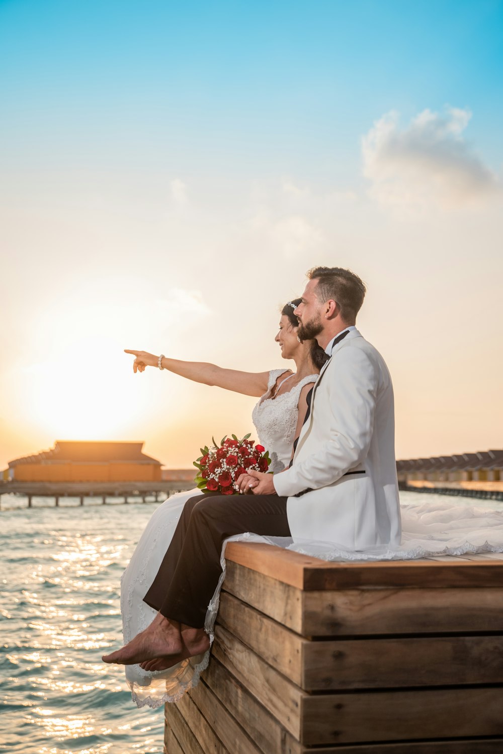 man in white suit kissing woman in white dress during daytime