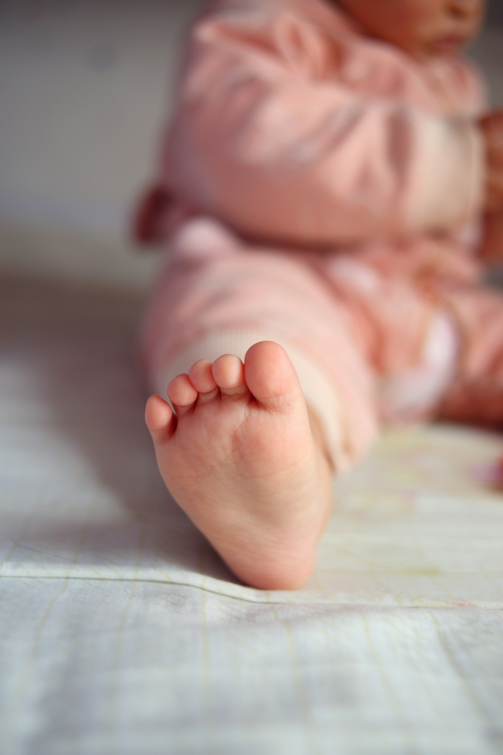 a baby laying on a bed with its feet up